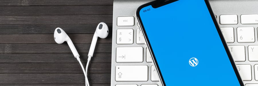 Picture of headphones and an iphone with a wordpress logo